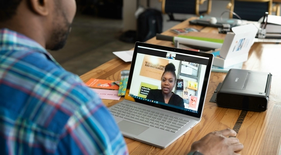Man with a laptop having a virtual meeting with a woman